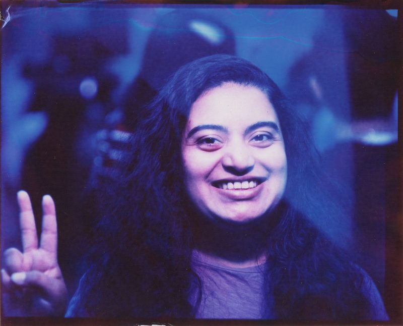 Smiling woman making a peace sign in a color portrait from Fremont Fridays